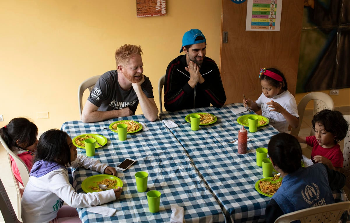 UNHCR er Jesse Tyler Ferguson (centre) and his husband Justin Mikita (centre-right) spend time with Venezuelan refugee and migrant children at the Casa Maristas, a day care for children while parents settle their legal migration status, look for employment and housing in Bogota. Colombia. UNHCR er Jesse Tyler Ferguson (centre) and his husband Justin Mikita (centre-right) spend time with Venezuelan refugee and migrant children