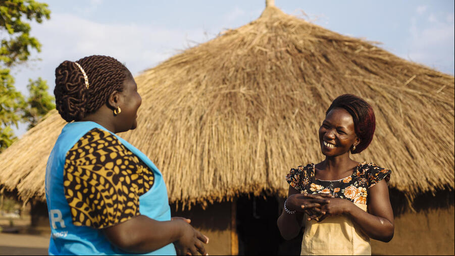 Dos mujeres africanas conversan; una de ellas (la que está a la izquierda) trabaja en ACNUR.