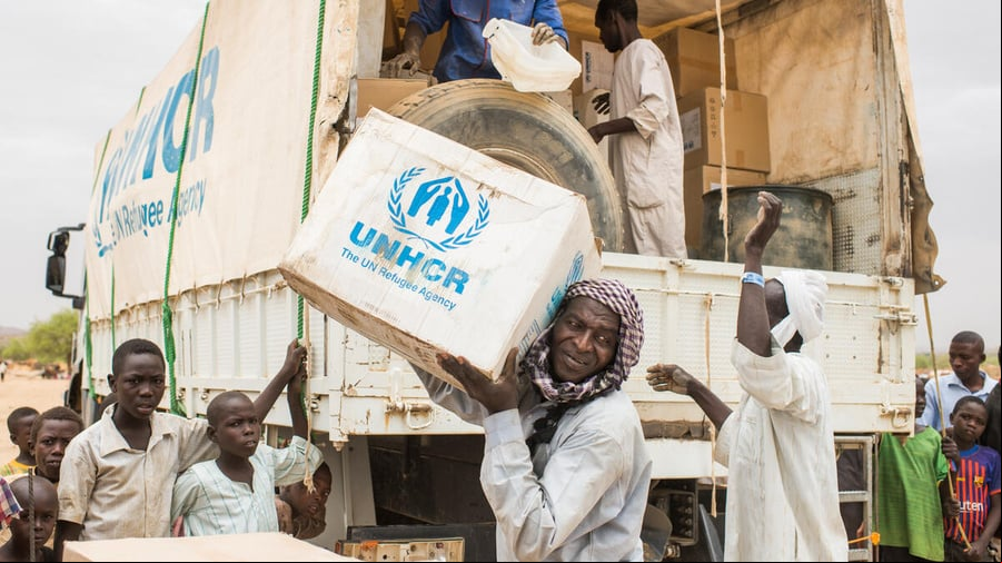 Un grupo de hombres descarga suministros de ACNUR de un camión en Chad